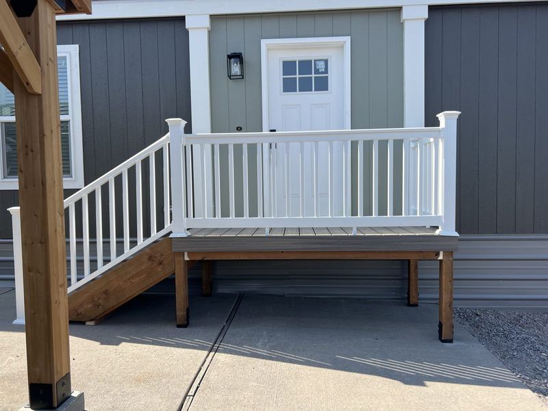 Deck, stairs and white railing built for a home in a mobile home community