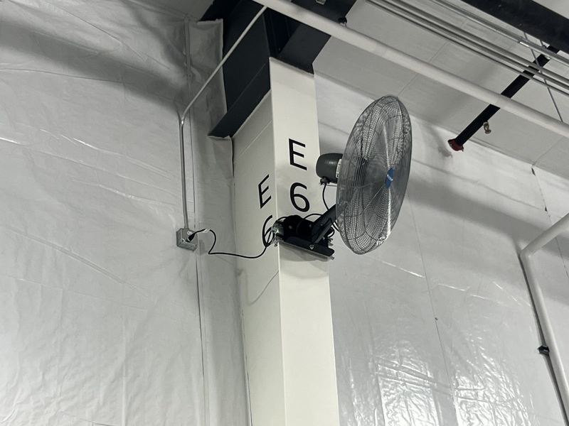Industrial wall fans mounted on warehouse columns